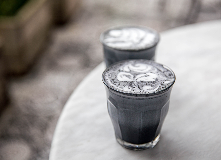 Two charcoal super latte on marble background.