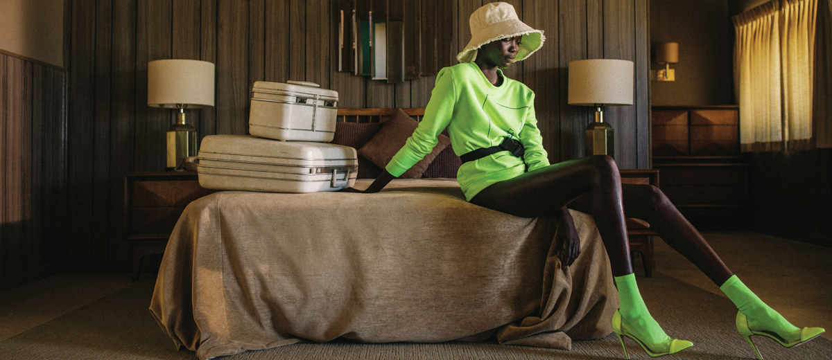 frau auf bett mit grünem neon pullover