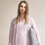 junges model von zara trägt gemütliche loungewear und kissen unter dem arm