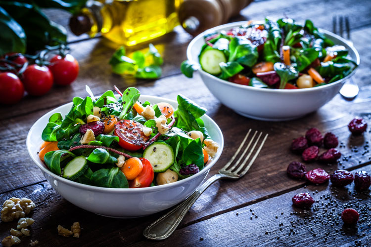 zwei schüsseln mit salat auf einem tisch