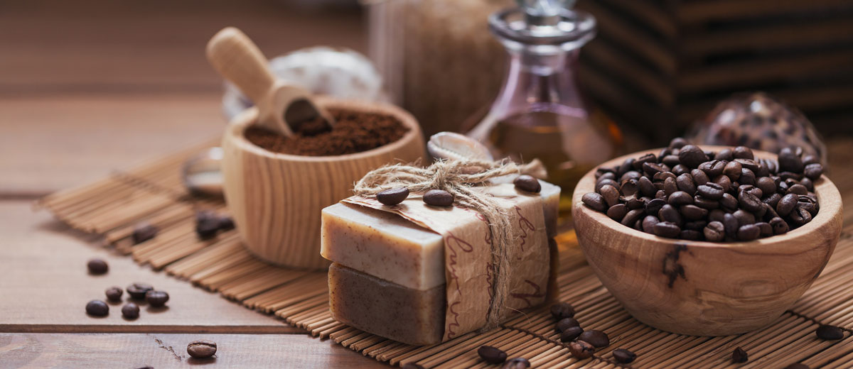 kaffeebohnen, gemahlener kaffee und seife aus kaffee auf einem holztisch