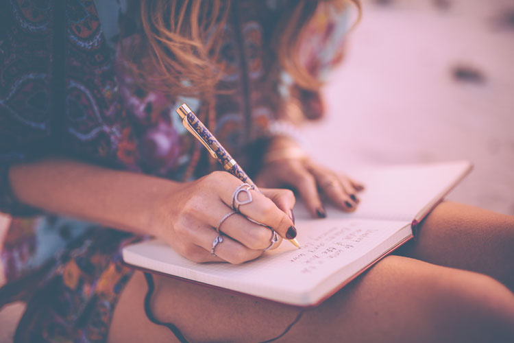 frau im boho-stil schreibt in ein tagebuch