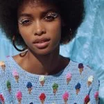 junge frau mit afro unnd hellblauem strickpullover mit eis-print