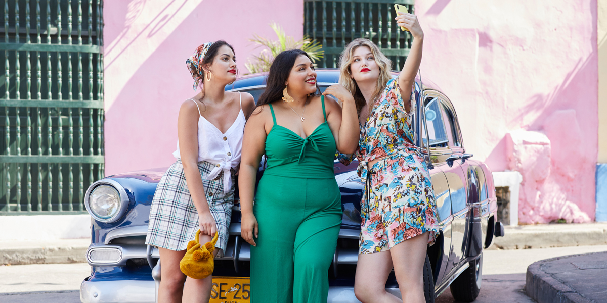 drei plus size models stehen vor einem auto und machen ein selfie