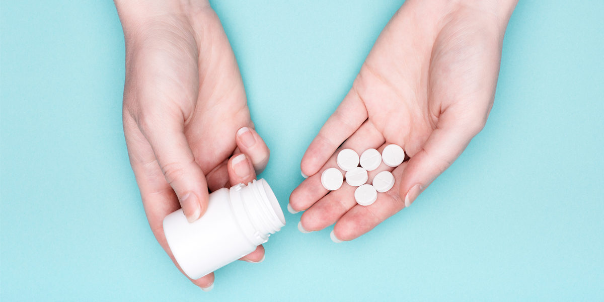 frau mit tabletten in der hand