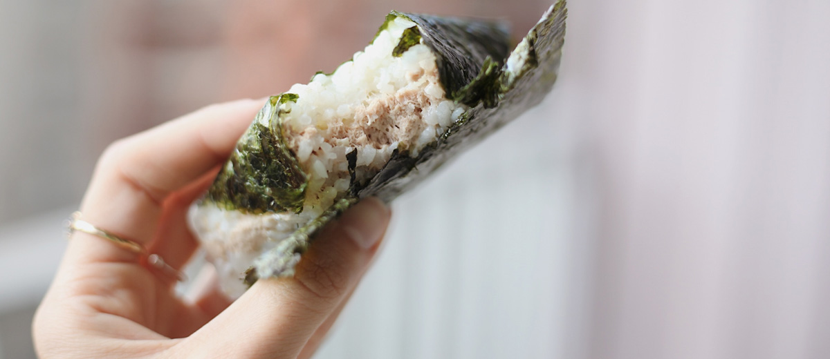 frau hält rin japanischen snack in der hand