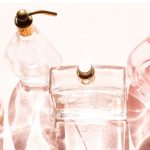 vier parfum flacons auf rosafarbener unterlage