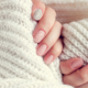 Frauenhände mit Knit Nails und Schal