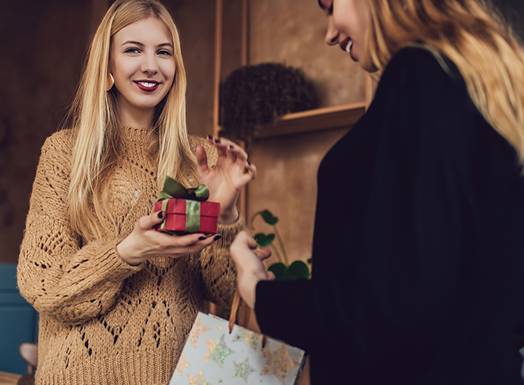 Freundinnen schenken sich gegenseitig Weihnachtsgeschenke